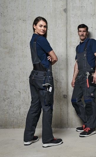 Woman in working dungarees for ladies, posing in front of the camera.
